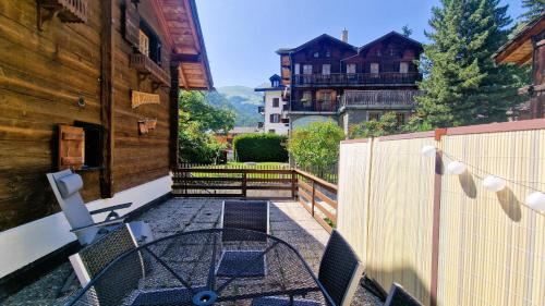 a table and chairs on a balcony with a fence at Chalet Lu Verzache 5 personnes in Evolène