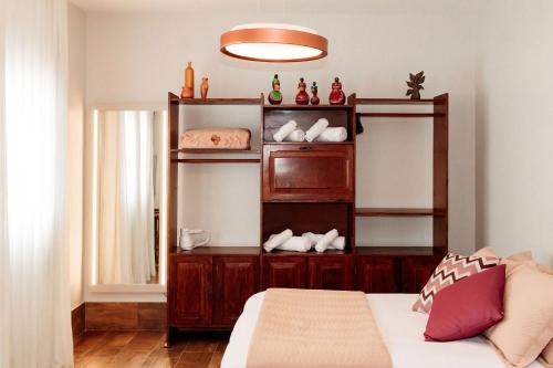 a room with a bed and a shelf with shoes at Casa Duplex c/ suíte cozinha completa e ventilador in Diamantina