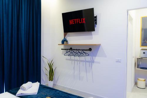 a room with a tv on a wall with at 5 Stars - Exclusive Luxury Suites with a jacuzzi in Trapani