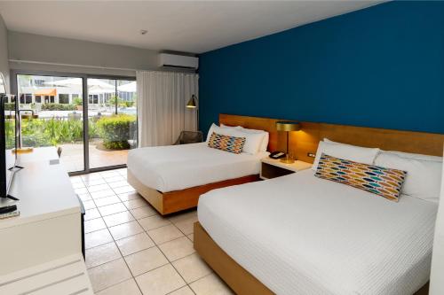 a bedroom with two beds and a blue wall at Rincon of the Seas Grand Caribbean Hotel in Rincon