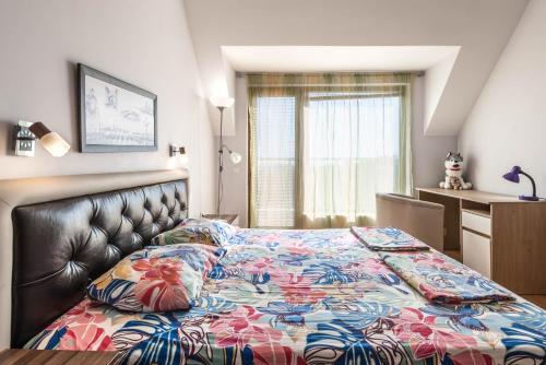 ein Schlafzimmer mit einem Bett mit geblümter Tagesdecke in der Unterkunft FANTASY APARTMENTS in Warna