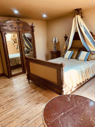 une chambre avec un lit et un grand miroir dans l'établissement Séjournez dans la Tour !, à Ploërmel