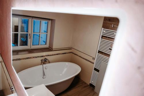 a bathroom with a tub and a window at Silberleithen Estate in Biberwier