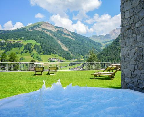 a patio with benches and a view of mountains at Hotel Chalet Dlaces in Selva di Val Gardena