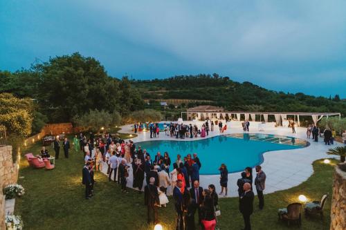 a group of people standing around a pool at a party at Leano Agriresort in Piazza Armerina