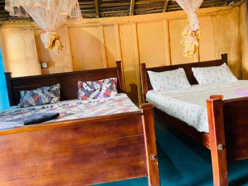 deux lits côte à côte dans une pièce dans l'établissement Vitamin sea beach cabana & hostel, à Nilaveli