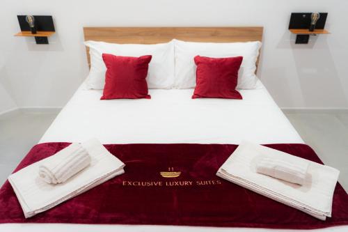 a large bed with red pillows on it at 5 Stars - Exclusive Luxury Suites with a jacuzzi in Trapani