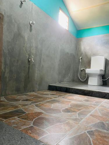 a bathroom with a toilet in the corner of a room at Vitamin sea beach cabana in Nilaveli