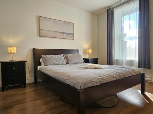 Un dormitorio con una cama grande y una ventana. en Le Mont-Royal Sky by HomeInMontreal, en Montreal