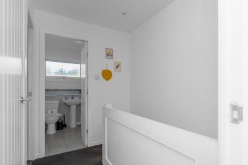 a white bathroom with a toilet and a sink at Free Parking - Central - Sleeps 6 - 2 Bedrooms in Livingston