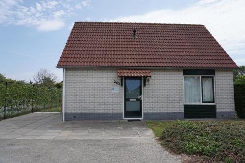 a small white house with a red roof at Kustverhuur, Park Schoneveld Stern 263 in Breskens