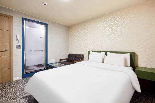 a hotel room with a large bed and a window at Galleria Hotel in Suwon