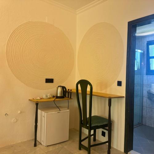 a table with a chair and two paper plates on the wall at Club Mel Holiday in Ortaca