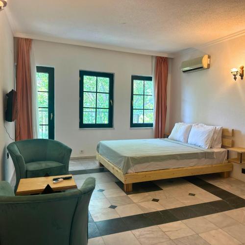 a bedroom with a bed and a chair at Club Mel Holiday in Ortaca