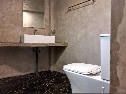 a bathroom with a white toilet and a sink at Suna's Place in Ahangama