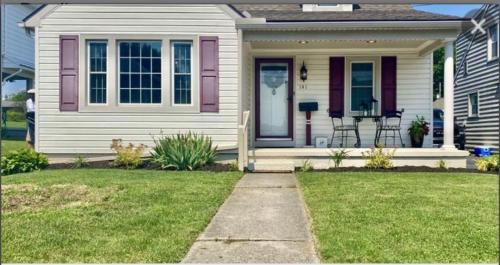 a white house with a pink door and chairs on the porch at Family Home in mainheim PA close to atractions in Manheim