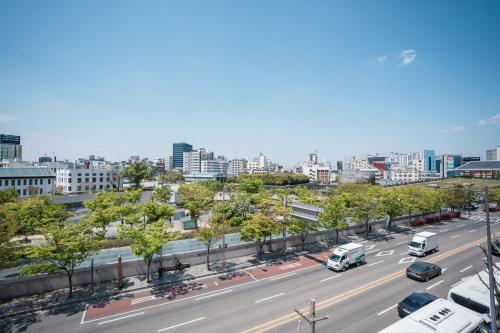 a view of a city street with cars and buses at Panda Guesthouse in Gwangju
