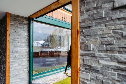 a window in a brick building with a view of a yard at Silberleithen Estate in Biberwier