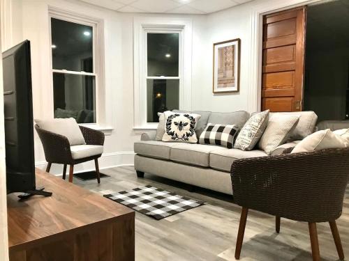 una sala de estar con un sofá y una silla en Cozy Lancaster Apartment Near Attractions, en Lancaster