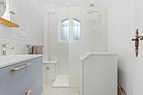 une salle de bain blanche avec une douche et un lavabo dans l'établissement Appartement 80m² Dans Villa Piscine, à Fréjus