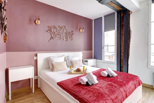 - une chambre avec un grand lit blanc et une couverture rouge dans l'établissement Bluestay 226 - Charmant appartement, à Paris