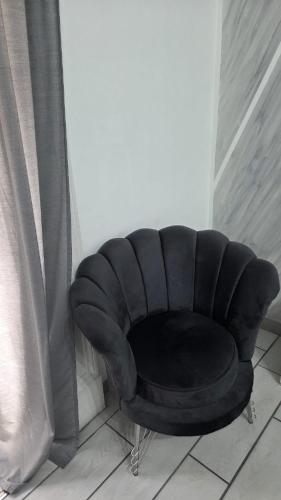 a black leather chair sitting next to a curtain at B&B La casa di Cò in Naples