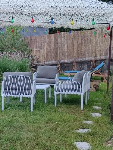 a group of benches sitting in the grass at Chambre de Charme dans maison d'hote "Le Petit Clouet" - Rochecorbon in Rochecorbon
