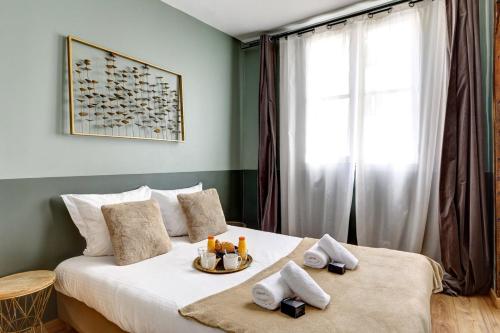 une chambre avec un lit avec des serviettes dessus dans l'établissement Bluestay 226 - Charmant appartement, à Paris