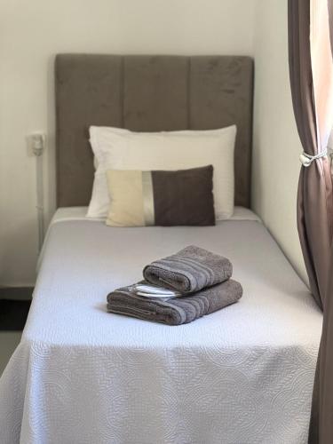 パトモスにあるDominik apartment 2のベッド1台(タオル2枚付)