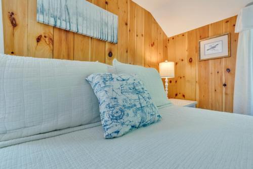 a bed with a blue and white pillow on it at Your Trail's End in Maine in Wayne