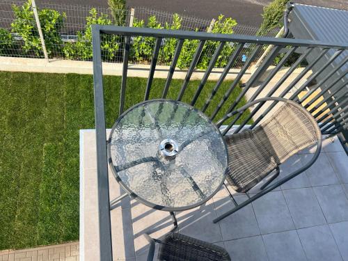 a glass table and a chair on a balcony at Vila Marbo in Baile Felix