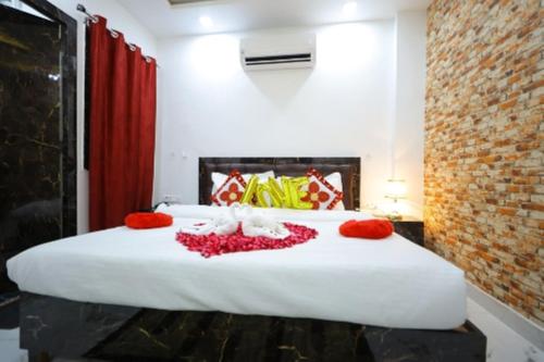 a bedroom with a large white bed with red flowers on it at Hotel Rajani Best Hotel In Bareilly AC OR NON AC Room in Bareilly
