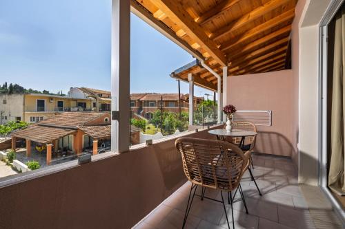 a balcony with a table and chairs on a balcony at Dominoes Corfu in Ýpsos