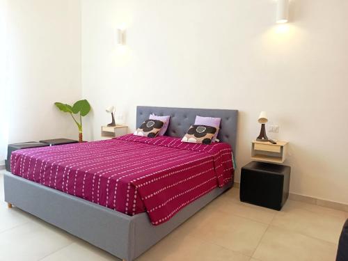 a bedroom with a bed with a pink comforter at Alghero Vacanza in Alghero