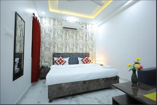 a bedroom with a large white bed with red pillows at Hotel Rajani Best Hotel In Bareilly AC OR NON AC Room in Bareilly