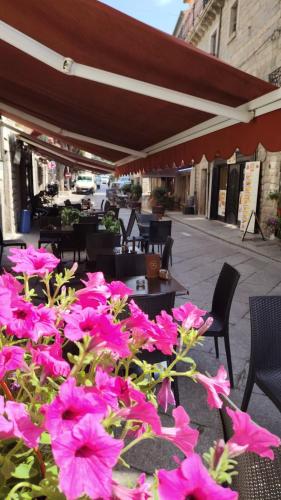 a bunch of pink flowers in front of a patio at Camere del Corso in Tempio Pausania