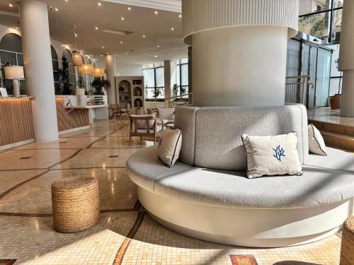 a couch in the middle of a lobby at PONTIANA Thalasso Hotel in Oropesa del Mar