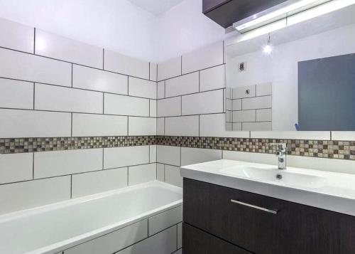 une salle de bain avec une baignoire et un lavabo et une baignoire dans l'établissement Superbe Appt Port Marianne, Parking Privé, 4 personnes, à Montpellier