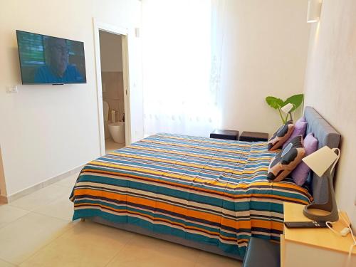 a bedroom with a bed with a colorful blanket at Alghero Vacanza in Alghero