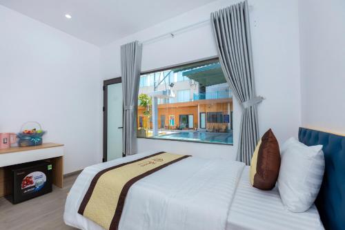 Resort Mini Mới Khai Trương في فنغ تاو: غرفة نوم بها سرير ونافذة كبيرة