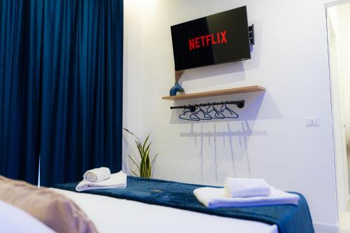 a room with two beds and a tv on the wall at 5 Stars - Exclusive Luxury Suites with a jacuzzi in Trapani