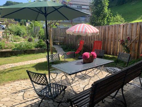 a table and chairs with an umbrella and a table and chairs sidx sidx sidx sidx at Gemütliches Chalet-Zimmer in Farmhouse Rosalie in Brunnadern