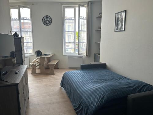 une chambre avec un lit et deux fenêtres dans l'établissement Chez Zélie, à Saintes