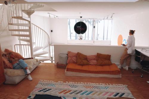 a woman standing in a living room with a couch at STAY OPEN Venice Beach in Los Angeles