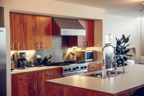 a kitchen with wooden cabinets and a stove top oven at STAY OPEN Venice Beach in Los Angeles