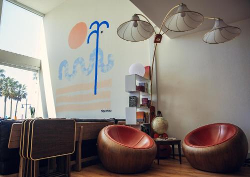 two ottoman chairs in a living room with a lamp at STAY OPEN Venice Beach in Los Angeles