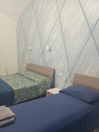 a bedroom with two beds and a wall at B&B La casa di Cò in Naples