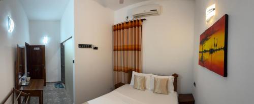 a bedroom with a bed and a painting on the wall at Negombo Signature Villa in Negombo