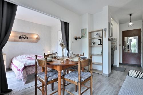 une salle à manger avec une table et un lit dans l'établissement L'Encatador - Bagnère-de-Luchon, à Saint-Mamet