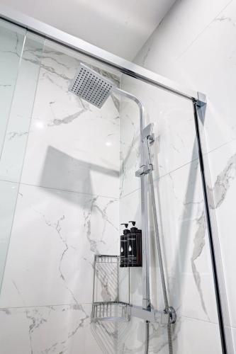 La salle de bains en marbre blanc est pourvue d'une douche. dans l'établissement Bluestay 288 - Superbe studio à Paris 17, à Paris